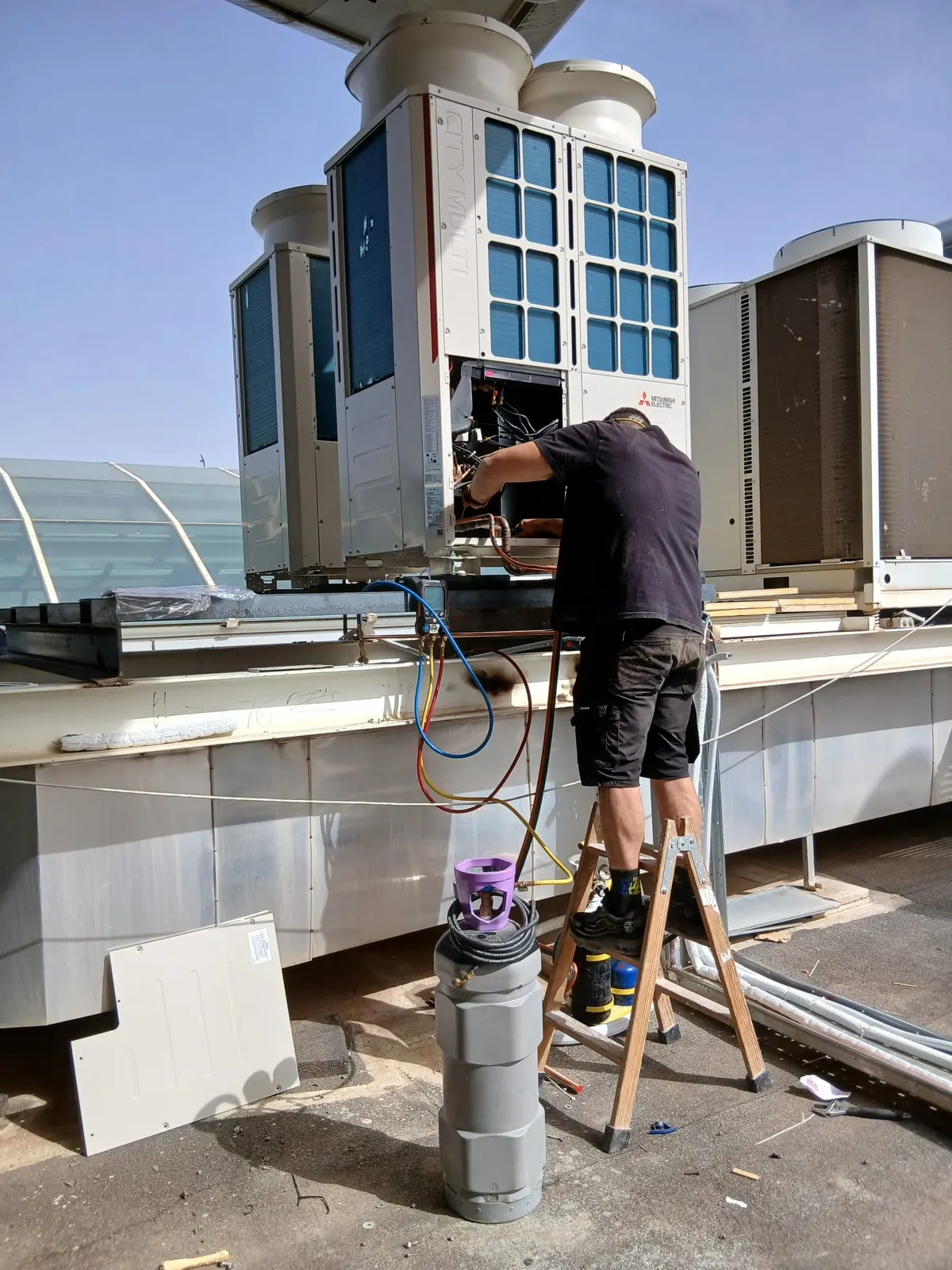 Técnico de Grupo 3 trabajando en una unidad exterior de climatización